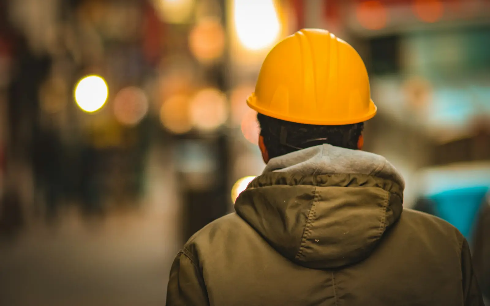 Operário de capacete amarelo olhando a obra
