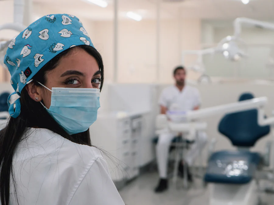 Dentista de máscara e touca sorrindo para a câmera