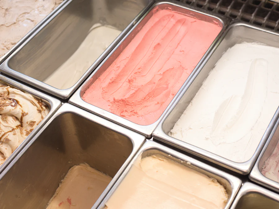 Vitrine de gelatos em cubas de inox, tons de rosa e creme